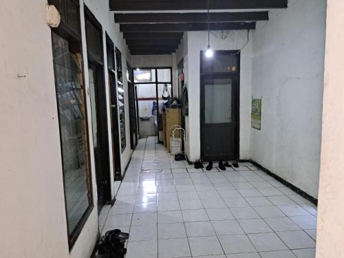 an empty hallway with a door and a tile floor at SPOT ON 93956 Siliwangi Guest House Syariah in Bandung