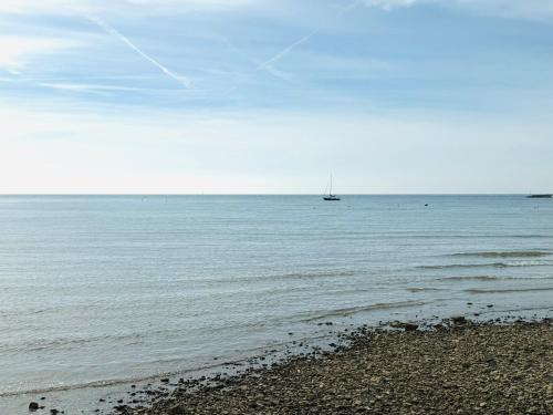 a sail boat in the ocean with a beach at Apartment Kontrada in Umag