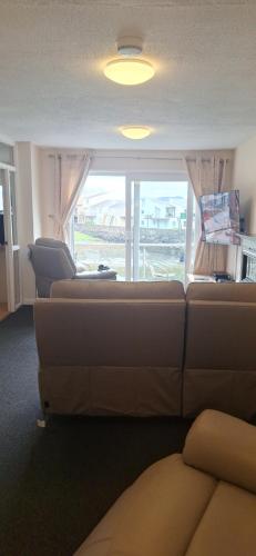 a living room with a couch and a window at Portmadog, Oakley Wharf in Porthmadog
