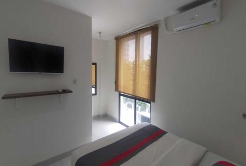 - une petite chambre avec un lit et une fenêtre dans l'établissement OYO 93958 J&B Smart Jatinegara, à Jakarta