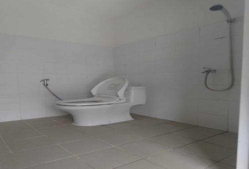 een witte badkamer met een toilet en een douche bij OYO 93958 J&B Smart Jatinegara in Jakarta
