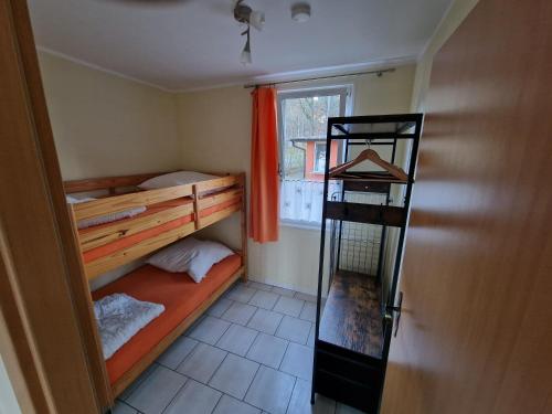 a small room with two bunk beds and a window at Ferienanlage "Am Sidowsee" in Himmelpfort