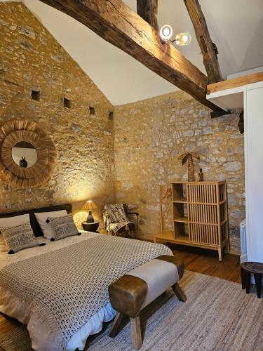 sypialnia z dużym łóżkiem i kamienną ścianą w obiekcie La Casa Nomade w mieście Issigeac