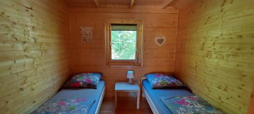 a room with two beds in a log cabin at Domki Pod Jaworem in Solina