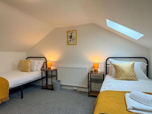 two beds in a room with two lamps on tables at Shrewsbury Townhouse in Harlescott