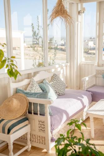 a bed sitting in a room with a window at Blue Kaouki Boutique Hotel in Sidi Kaouki