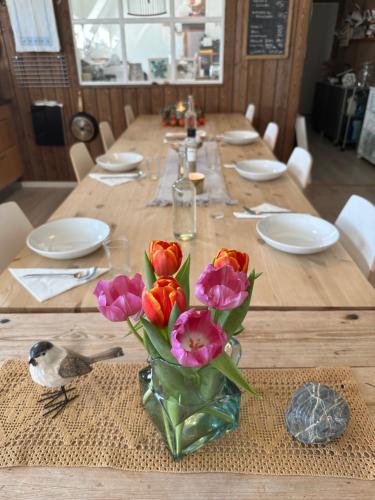 una mesa de madera con un jarrón de flores. en SAGA, badehotell med sauna og badebrygge - Inderøy en Straumen
