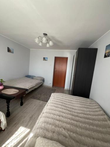 a room with two beds and a table in it at Apartament Kackówka in Gdynia