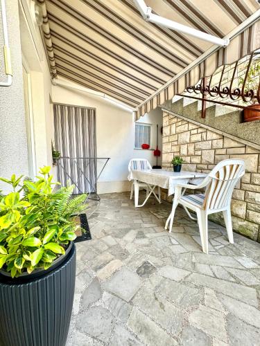 a patio with a table and chairs and plants at Apartment Kontrada in Umag