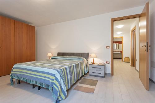 1 dormitorio con 1 cama con manta a rayas en Villino Elisa, en Tertenìa