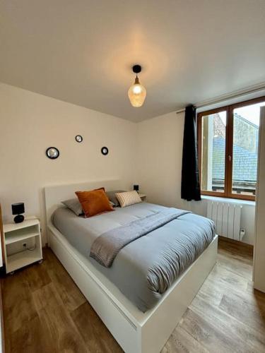 une chambre avec un grand lit avec une fenêtre dans l'établissement Appartement idéalement situé au cœur de Dieppe, à Dieppe