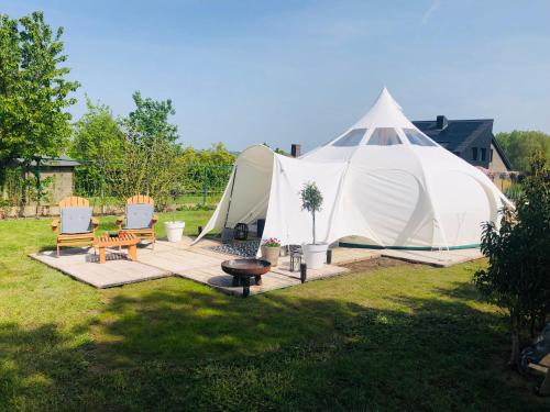 a tent in a yard with two chairs and a table at Glamping -Logie Moonlight in Brakel