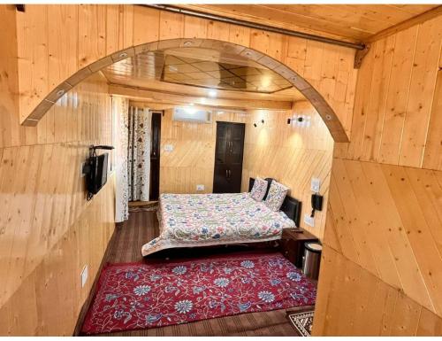 um quarto com uma cama num quarto de madeira em Hotel Nagview Cottage, Jammu and Kashmir em Gulmarg
