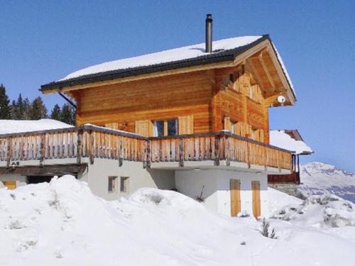 uma cabana de madeira com um deque na neve em A luxurious 6 person chalet with superb view em Les Collons