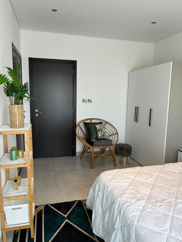 um quarto com uma cama, uma cadeira e uma porta em The Lennox by Luxe Properties em Acra