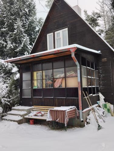 una pequeña casa con nieve en el porche en Chata u řeky Orlice en Hradec Králové