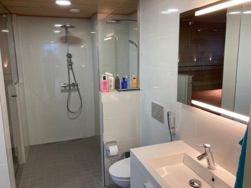 a bathroom with a shower and a toilet and a sink at Alvar 114 in Helsinki