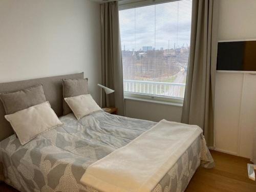a bedroom with a bed with a large window at Alvar 114 in Helsinki
