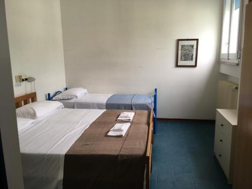 a room with two beds and a table with towels at Hotel Maddalena in Marina di Ravenna