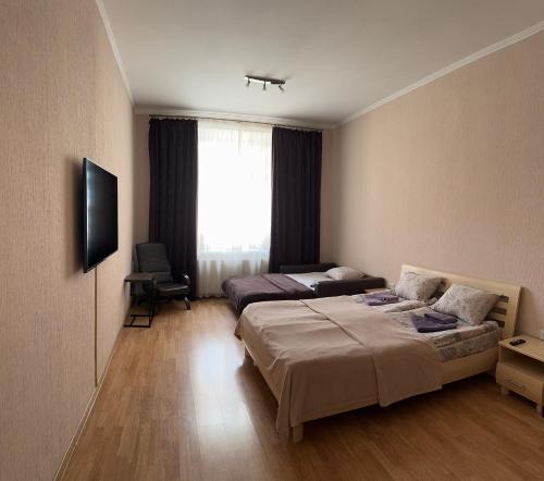 リヴィウにあるАпартаменти на Гнатюка 17のベッド2台とテレビが備わるホテルルームです。