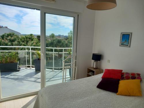 - une chambre avec un lit et une grande porte en verre dans l'établissement Bel appartement 75m2, à La Rochelle