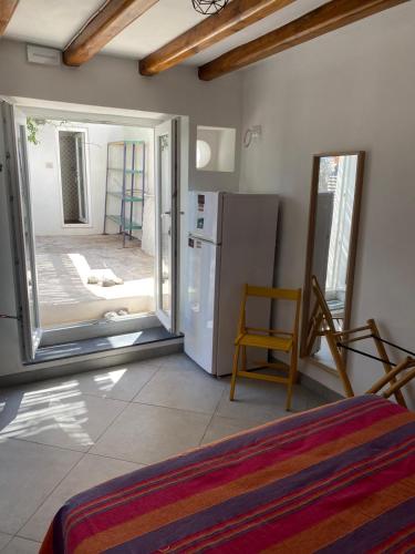 um quarto com um frigorífico e uma porta de vidro deslizante em Casa Lilian em Stromboli