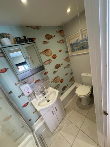 La salle de bains est pourvue d'un lavabo et de toilettes. dans l'établissement Charming one bedroom cottage, à Basingstoke