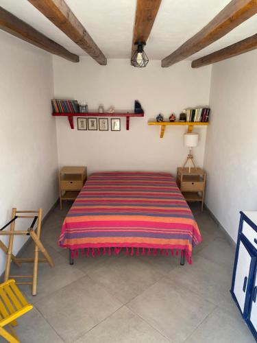 Casa Lilian في سترومبولي: غرفة نوم مع سرير وبطانية مخططة ملونة