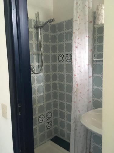 a bathroom with a shower curtain and a sink at Hotel Maddalena in Marina di Ravenna