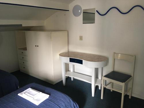 a bedroom with a desk and a bed and a desk at Hotel Maddalena in Marina di Ravenna
