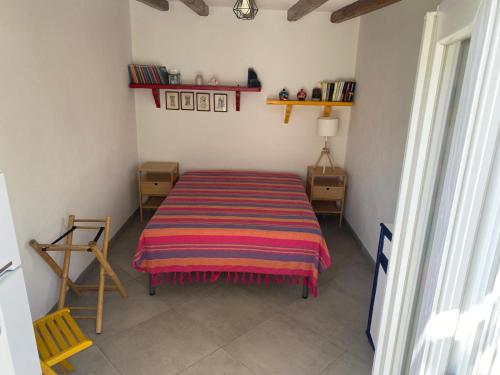 a bedroom with a bed with a striped blanket at Casa Lilian in Stromboli