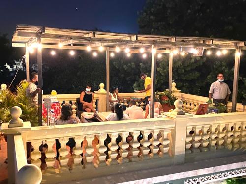 un gruppo di persone sedute su un patio di notte di Hotel Boutique Castillo Ines Maria a Cartagena de Indias