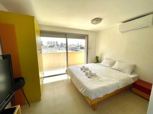a bedroom with a bed and a large window at Two Bedrooms Duplex Apartment l Bugrashov Street l by Bookiz in Tel Aviv
