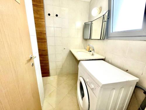 a bathroom with a washing machine and a sink at Two Bedrooms Duplex Apartment l Bugrashov Street l by Bookiz in Tel Aviv