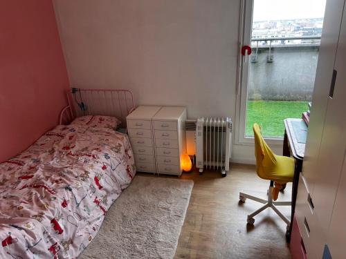 une chambre avec un lit, un bureau et une fenêtre dans l'établissement Rooftop Vue sur Paris Tour eiffel Cinq minutes du metro, à Villejuif