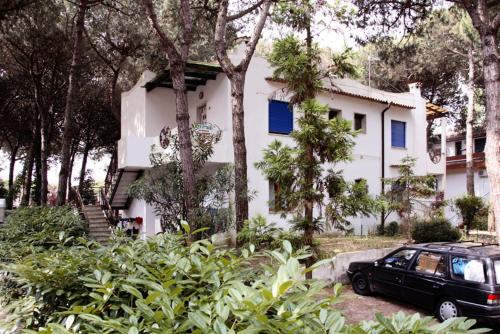 une voiture noire garée devant une maison blanche dans l'établissement Villa Zanella, à Rosolina Mare