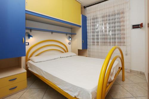 a bedroom with a bed with a yellow and blue headboard at Villa Zanella in Rosolina Mare