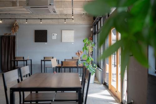 una sala da pranzo con tavoli, sedie e una pianta di &HouSE - Vacation STAY 52186v a Takagi