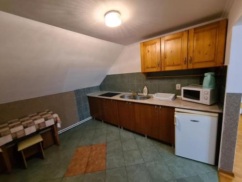 a kitchen with a sink and a microwave at Sándor Panzió in Praid