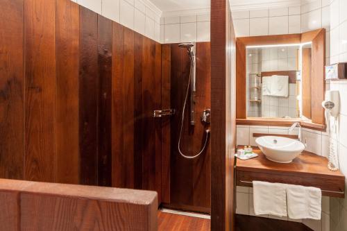uma casa de banho com um lavatório e um chuveiro. em Hotel Garni Ida em Ischgl