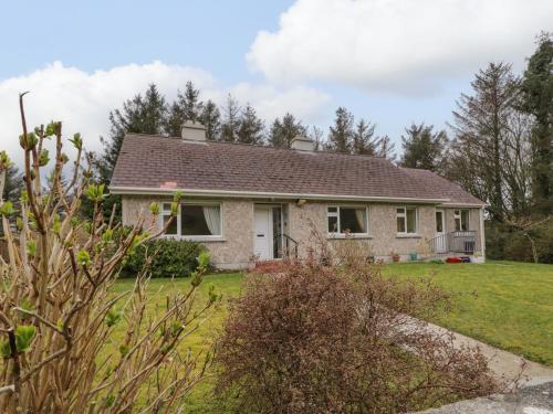 a brick house with a roof on a yard at James Neills Cottage in Letterkenny
