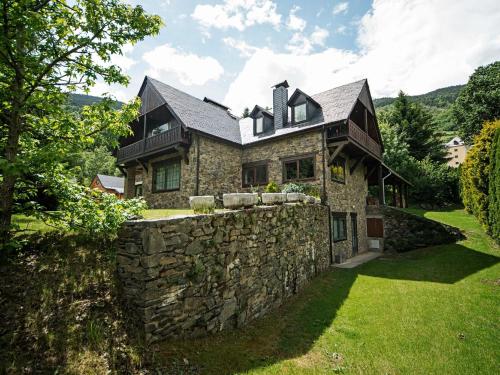 a stone house with a stone wall at Splendid house next to the Baqueira Beret ski resort in Vielha