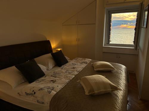 Schlafzimmer mit einem großen Bett und einem Fenster in der Unterkunft Apartmani Đurđica in Primošten