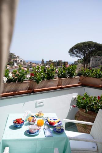 a table with plates of food on a balcony at Valle d'Amalfi Suites in Amalfi
