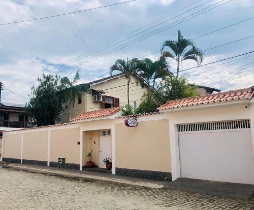 una casa con puertas blancas de garaje en una calle en Pousada Romã, en Paraty