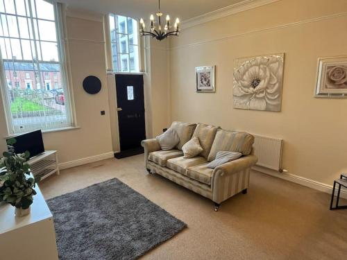 a living room with a couch and a table at Thurnams House, Ground Floor Apt in Carlisle