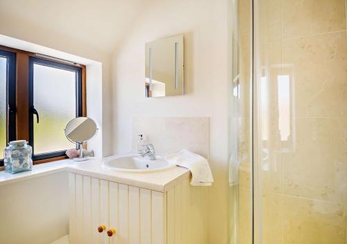 a white bathroom with a sink and a shower at Farriers Cottage - Cockthorpe in Stiffkey