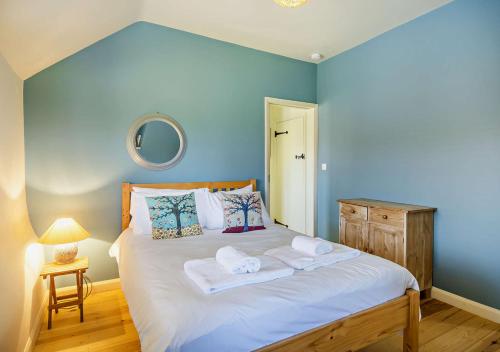 a blue bedroom with a bed with towels on it at Farriers Cottage - Cockthorpe in Stiffkey