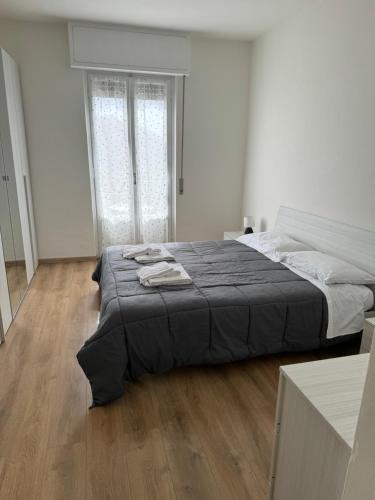 a large bed in a white room with wooden floors at Appartamenti Monti Como Lake in Brunate