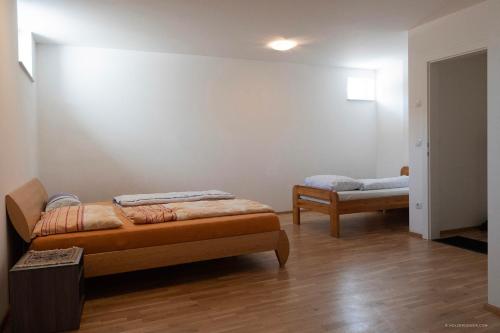 Duas camas num quarto com pisos em madeira em Apartment mit Garten em Dobl-Zwaring